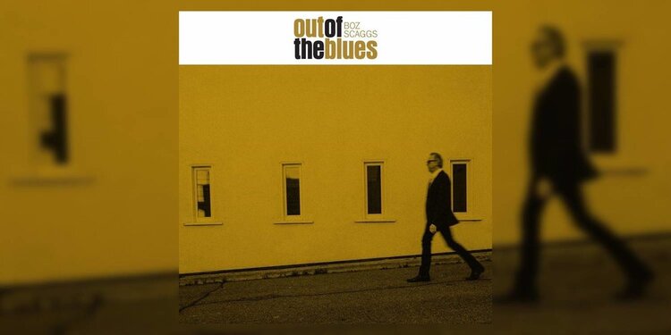 The album cover of Boz Skaggs 'Out of the Blues' featuring a yellow tinted photograph of Boz walking in front of a building