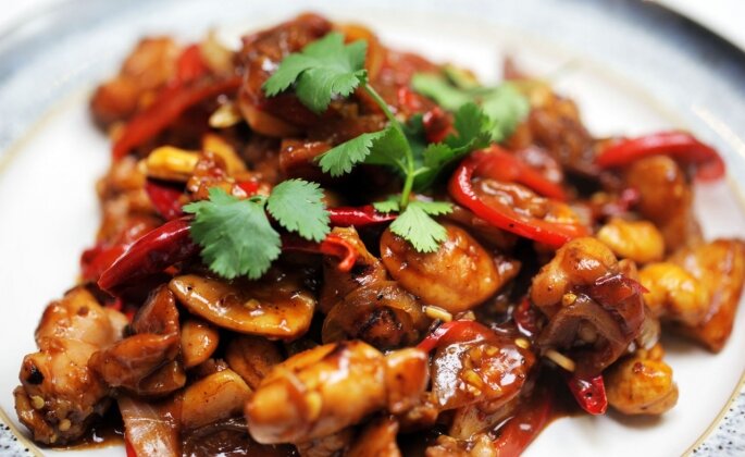 A plate of Kung Pao Chicken with fresh cilantro as garnish