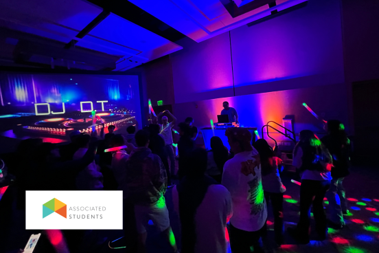 Associated Students Silent Disco A DJ performing and people dancing in a colorfully lit room