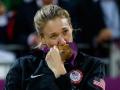 An Olympic Medalist kissing her Olympic gold medal with an emotional expression on her face
