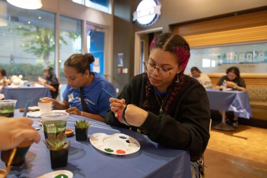 Student paints a flower pot