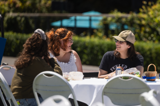 A group sits together with food and drinks