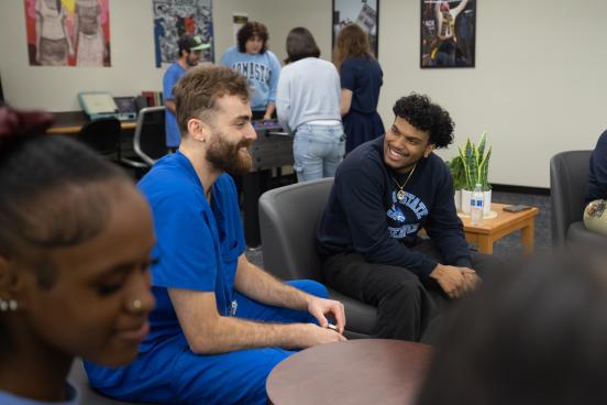 A group of students laugh in the HUB