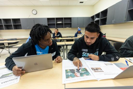 Two students sit together studying