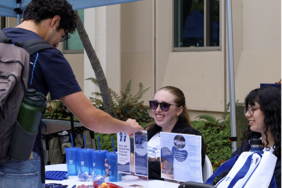 Student talks under an info tent