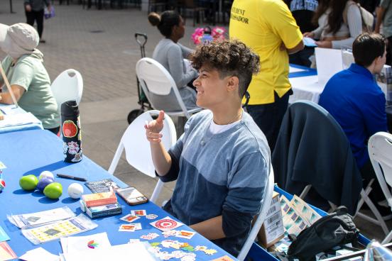 Student at a resource table smiling