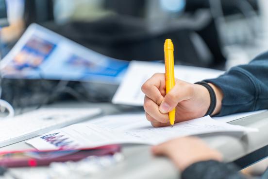 Close up of someone writing down notes