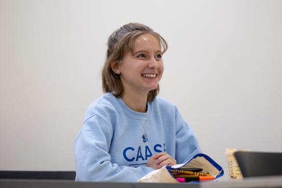 Student sitting at a desk smiling