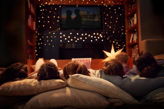 A family watches a movie under stars