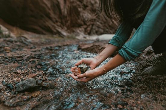 Someone gathering rocks by a stream