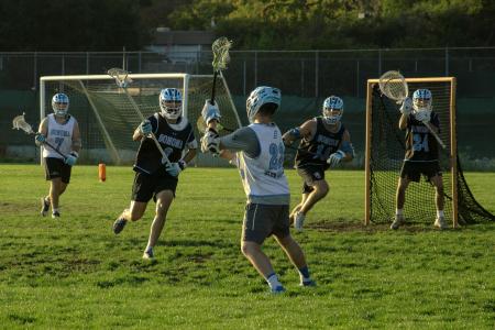 The SSU Men's Lacrosse team playing lacrosse on an outdoor field 