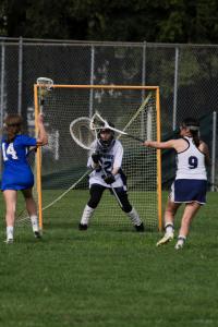 The SSU Women's Lacrosse team playing lacrosse on an outdoor field 
