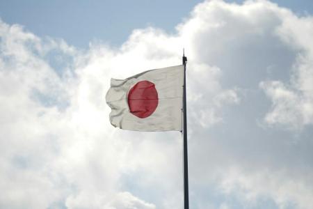 The Japanese flag with clouds behind it 