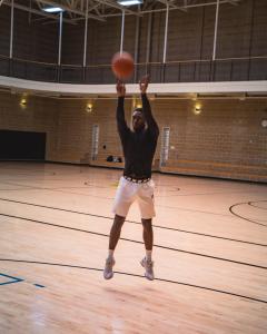 Someone throwing a basketball inside the indoor Recreation Center basketball court