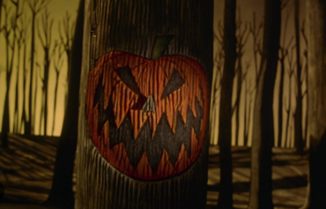 A Halloween jack-o-lantern carved into a tree