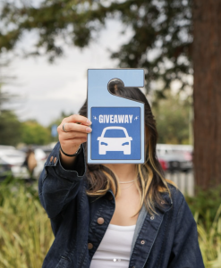 Someone holding a parking pass in front of their face