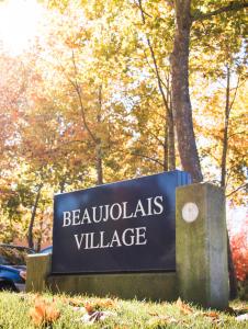 An outdoor sign for Beaujolais Village
