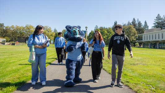 Students walking with Lobo (mascot)