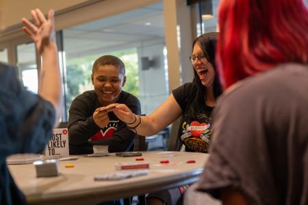 Group laughs together as they play cards