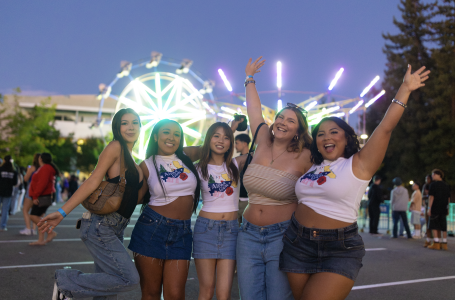 Group posing in front of lit-up carnival