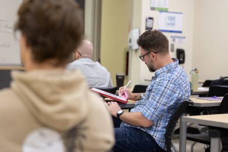 A student takes notes during a lecture