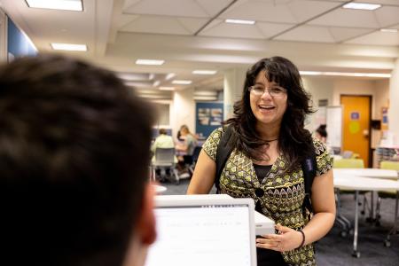 Someone speaks to a student at an info desk