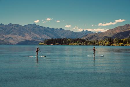 Two people paddle boarding on a lake
