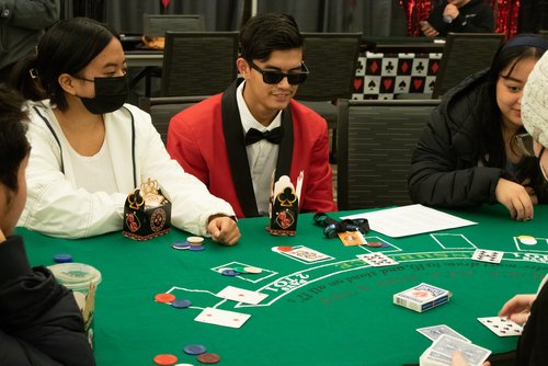 People playing a card game at a green card table