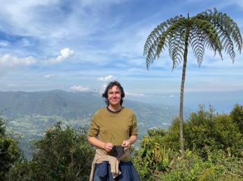 David Berenstein posing in front of a tropical landscape 