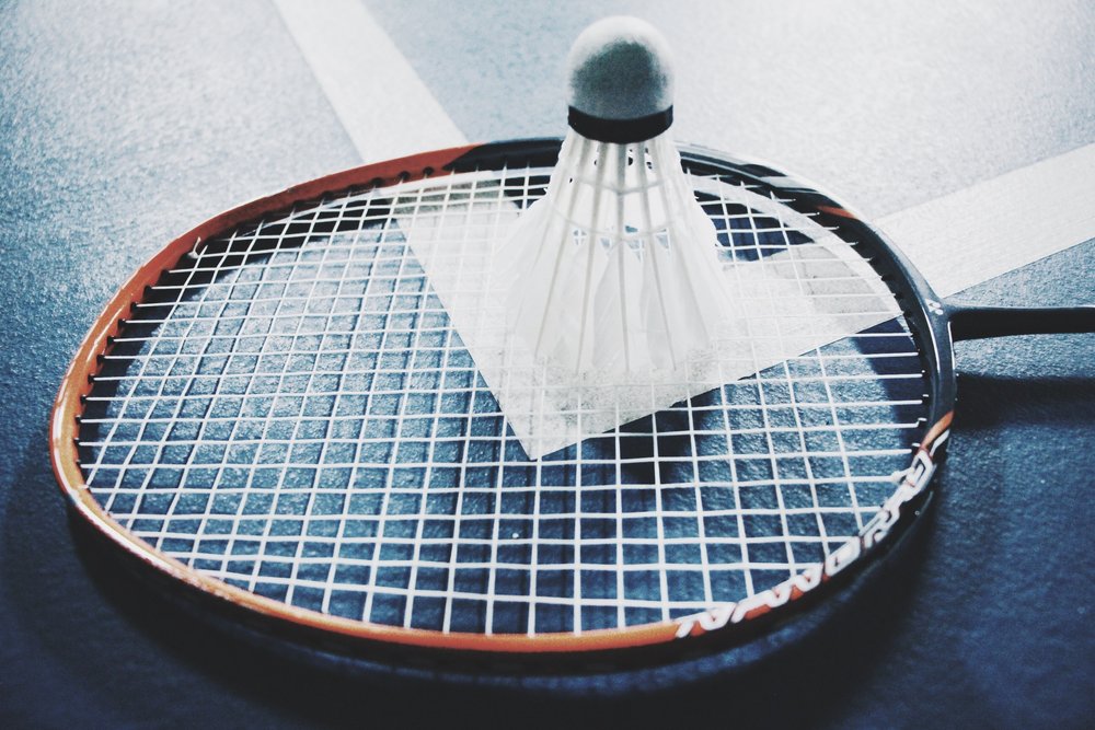 a badminton shuttlecock sitting atop a badminton racket