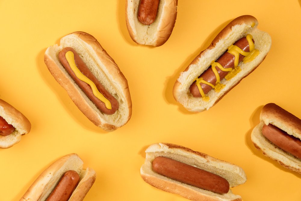 Hot dogs in front of a yellow background