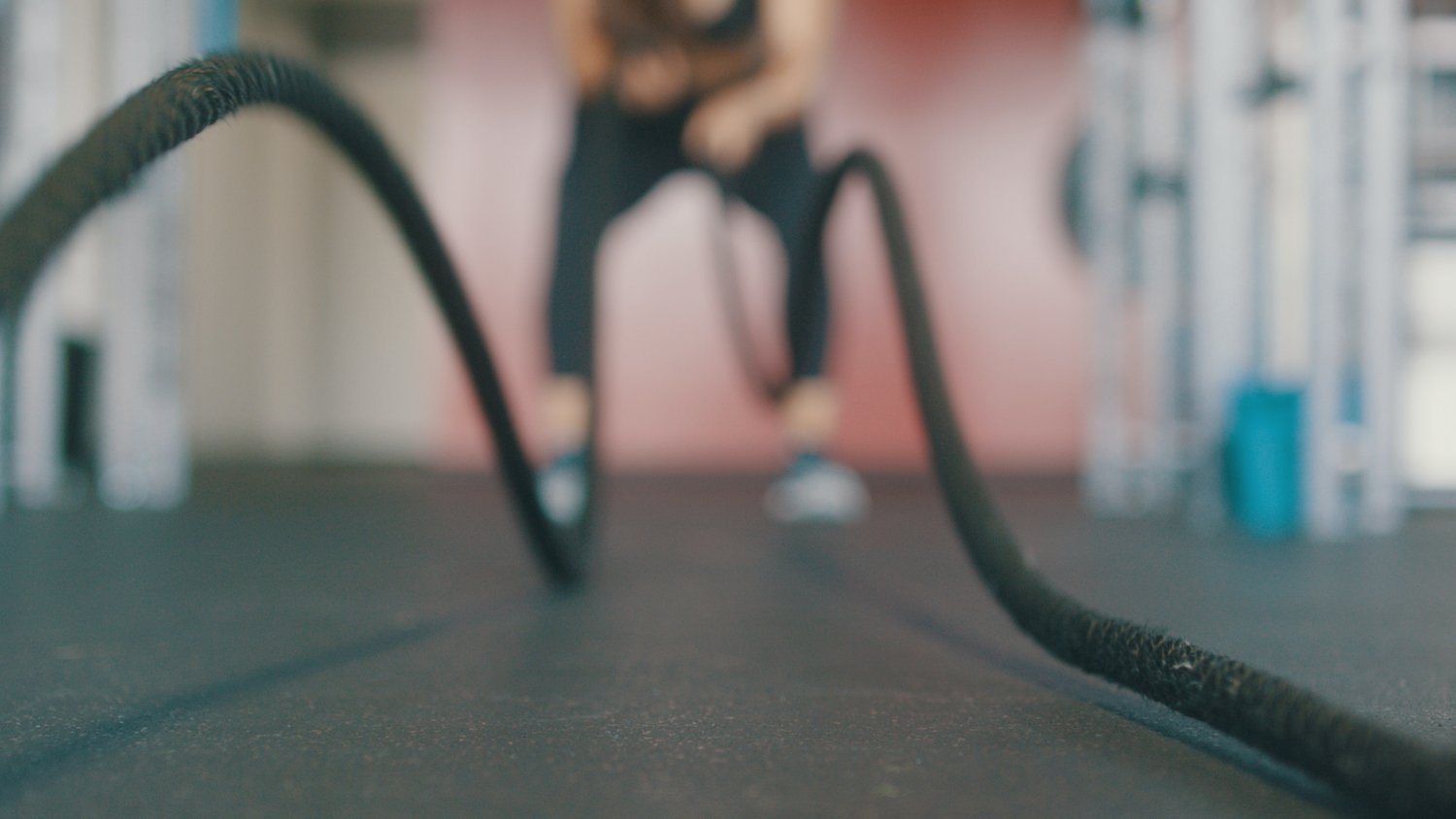 person using battle ropes at gym