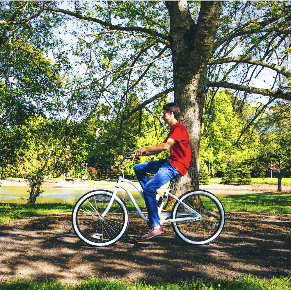 Someone riding a bicycle on a wooded and shaded path