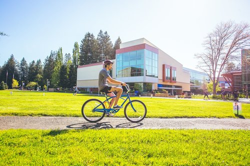 Student riding a bike on campus 
