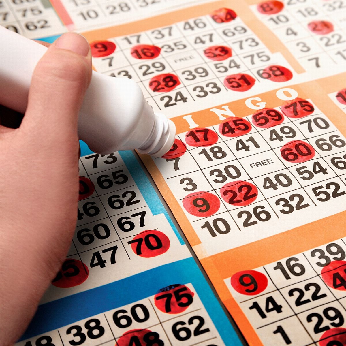 Someone marking a Bingo card with a red marker