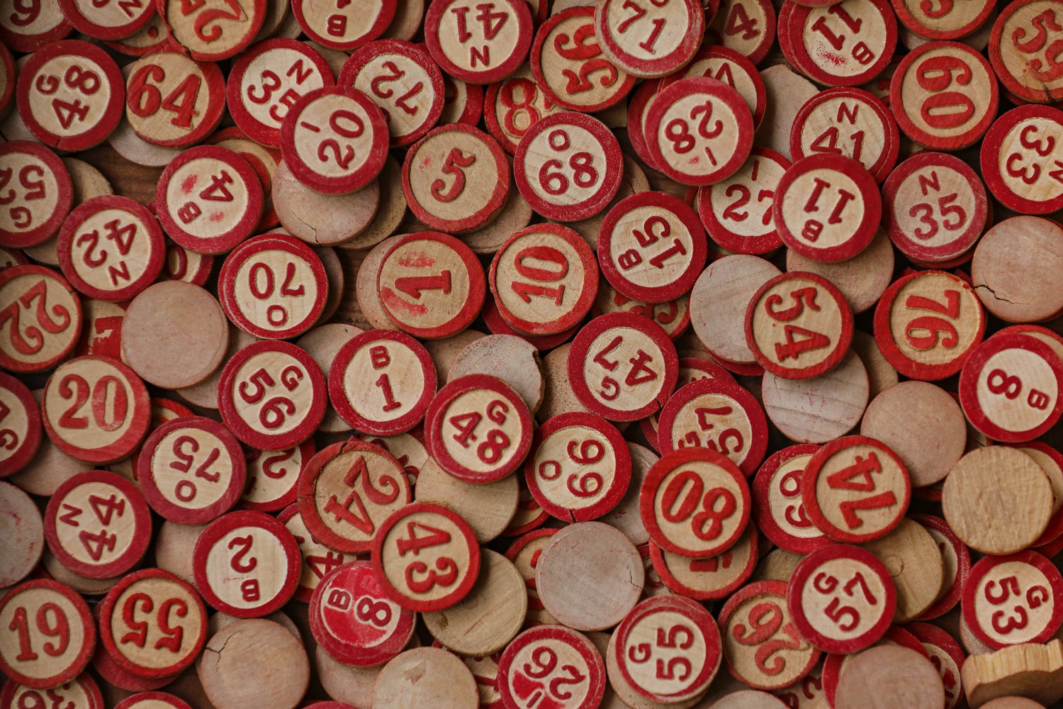 A pile of red BINGO coins with numbers on them 