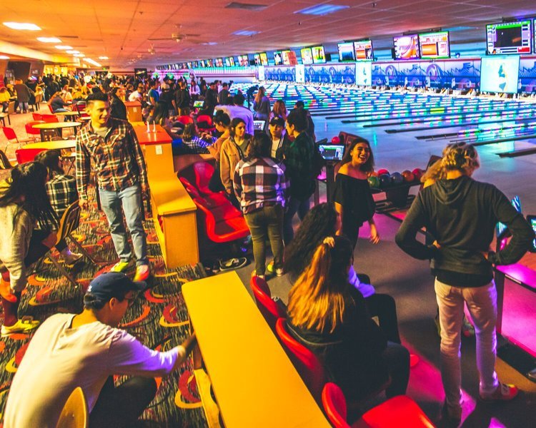 A large group of people bowling in a bowling alley