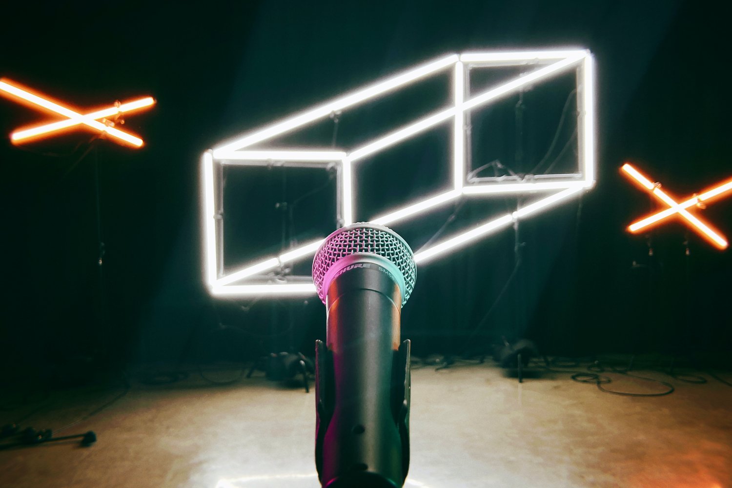 A microphone with colorful neon signs behind it