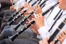 A row of people playing clarinets