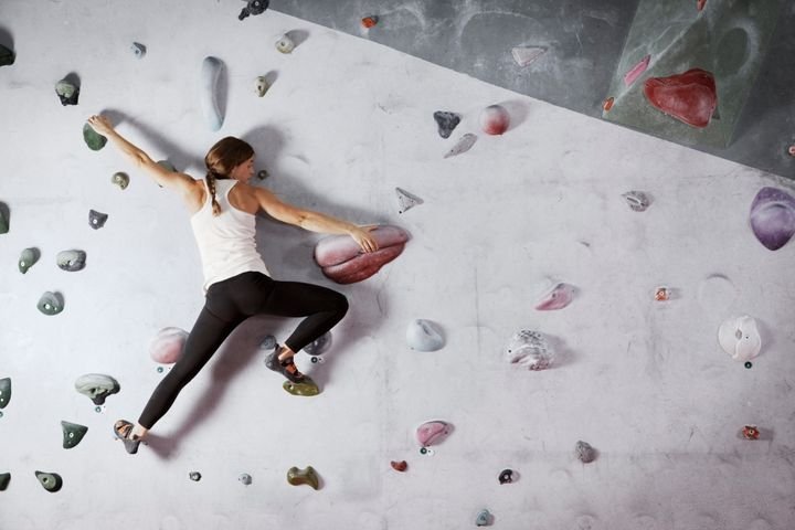 Someone rock climbing on an indoor rock wall 