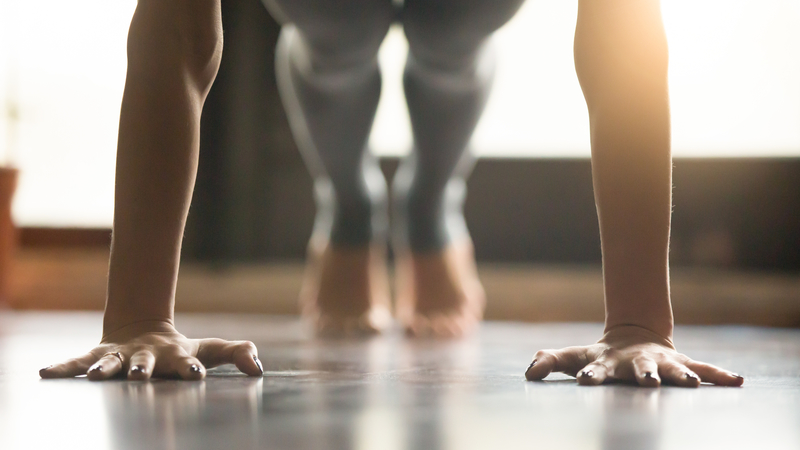 The hands and feet of someone doing a pushup indoors 