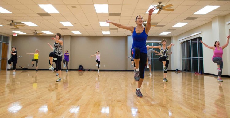 A group of people doing a dance exercise indoors