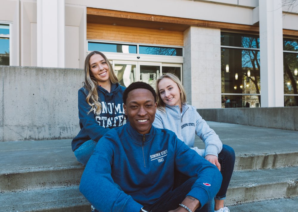 Students posing and smiling while wearing SSU merch