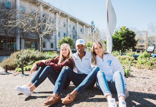 Students posing by the "bacon" statue 