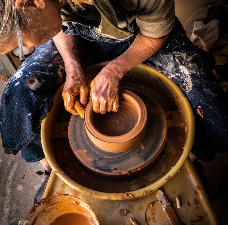 Someone spinning clay on a pottery wheel