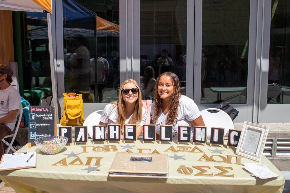 Two people sitting at table during Greek Recruitment