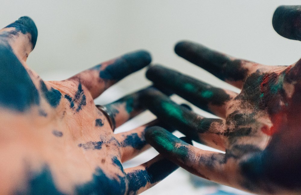 a pair of hands covered in paint