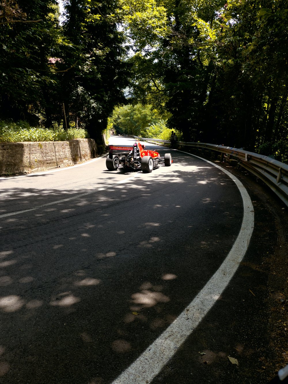 A red RC car driving down a curved road