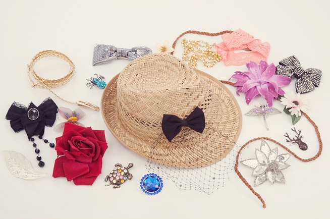 A hat surrounded by a variety of crafting materials and hat accessories 