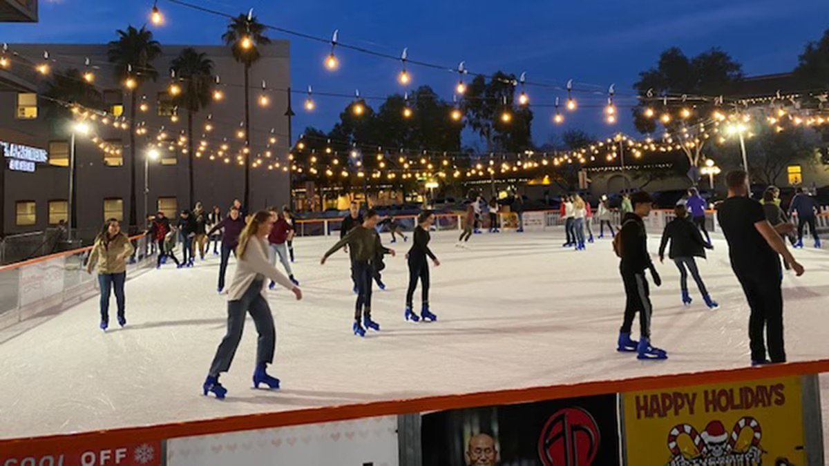people ice skating at an outdoor ice skating rink